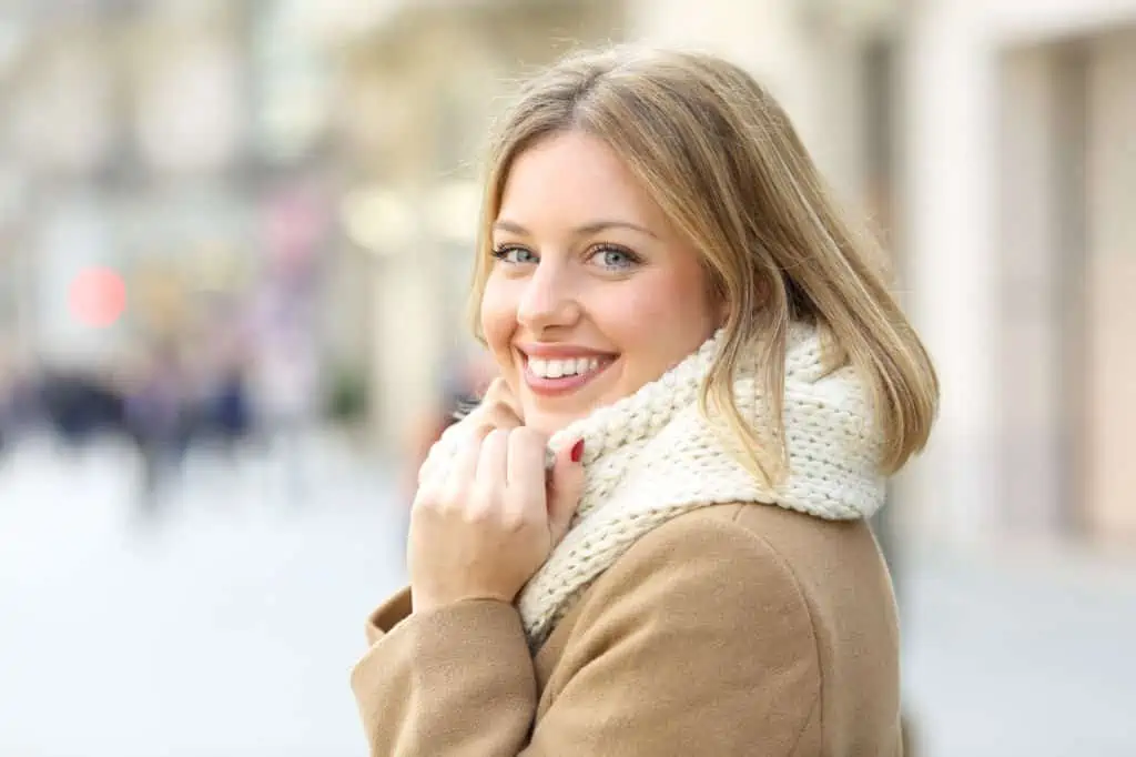 Portrait of a happy woman posing looking at camera in winter in the street