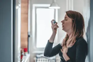 A woman using inhaler
