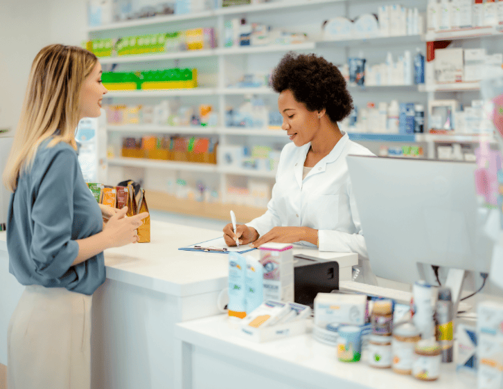 A woman asking a pharmacist about a medication
